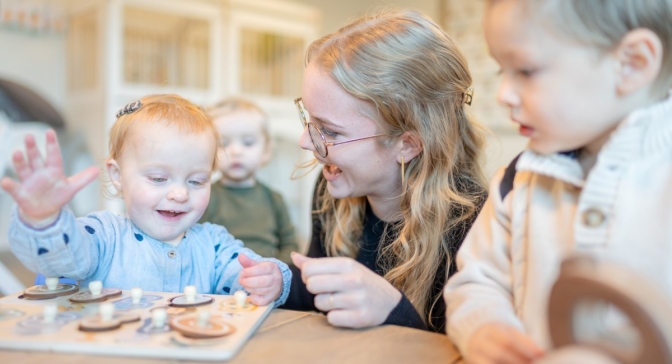 Pedagogisch medewerker doet puzzel met kinderen